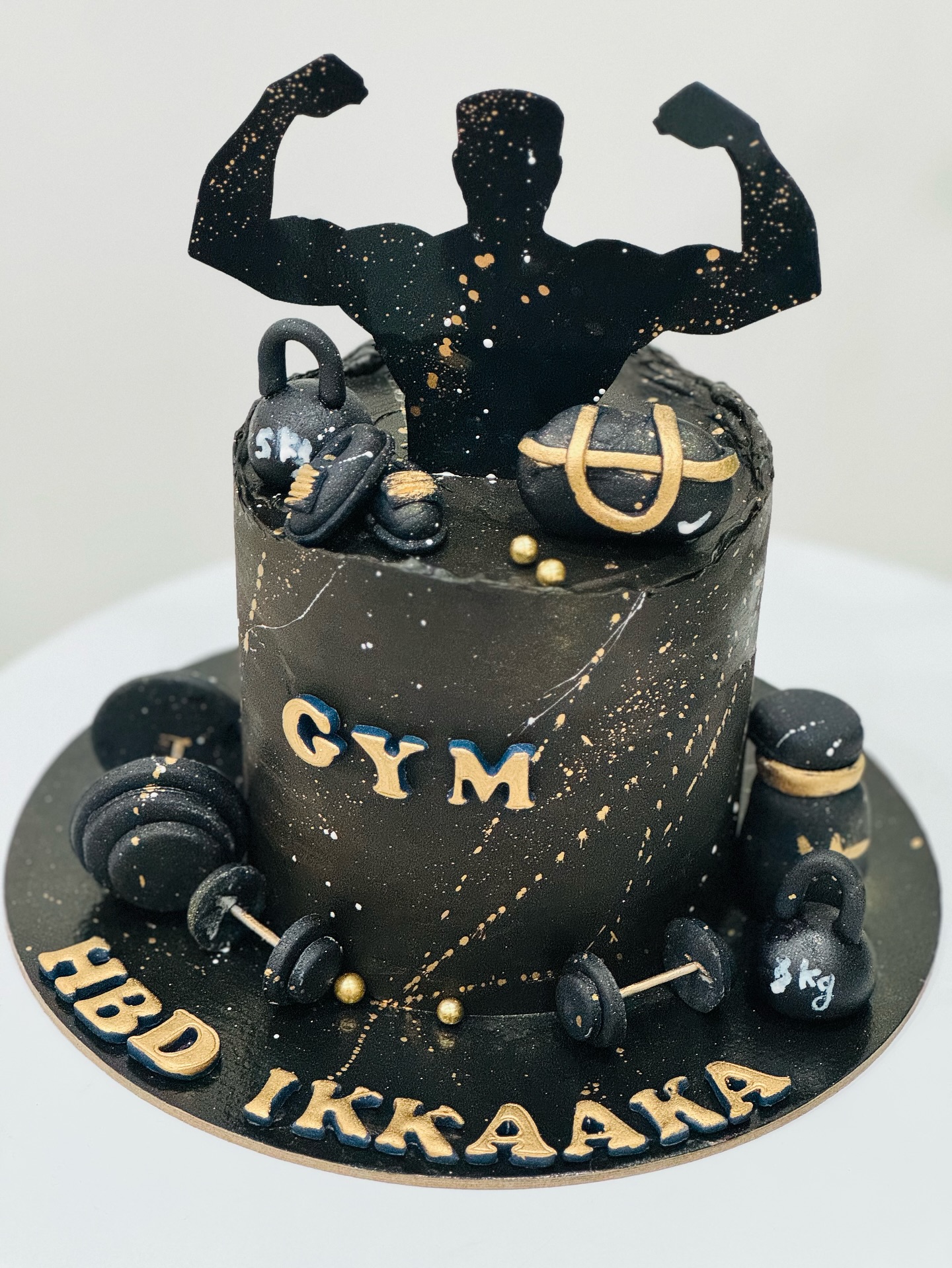 Black fitness themed birthday cake with gym details and gold splatter