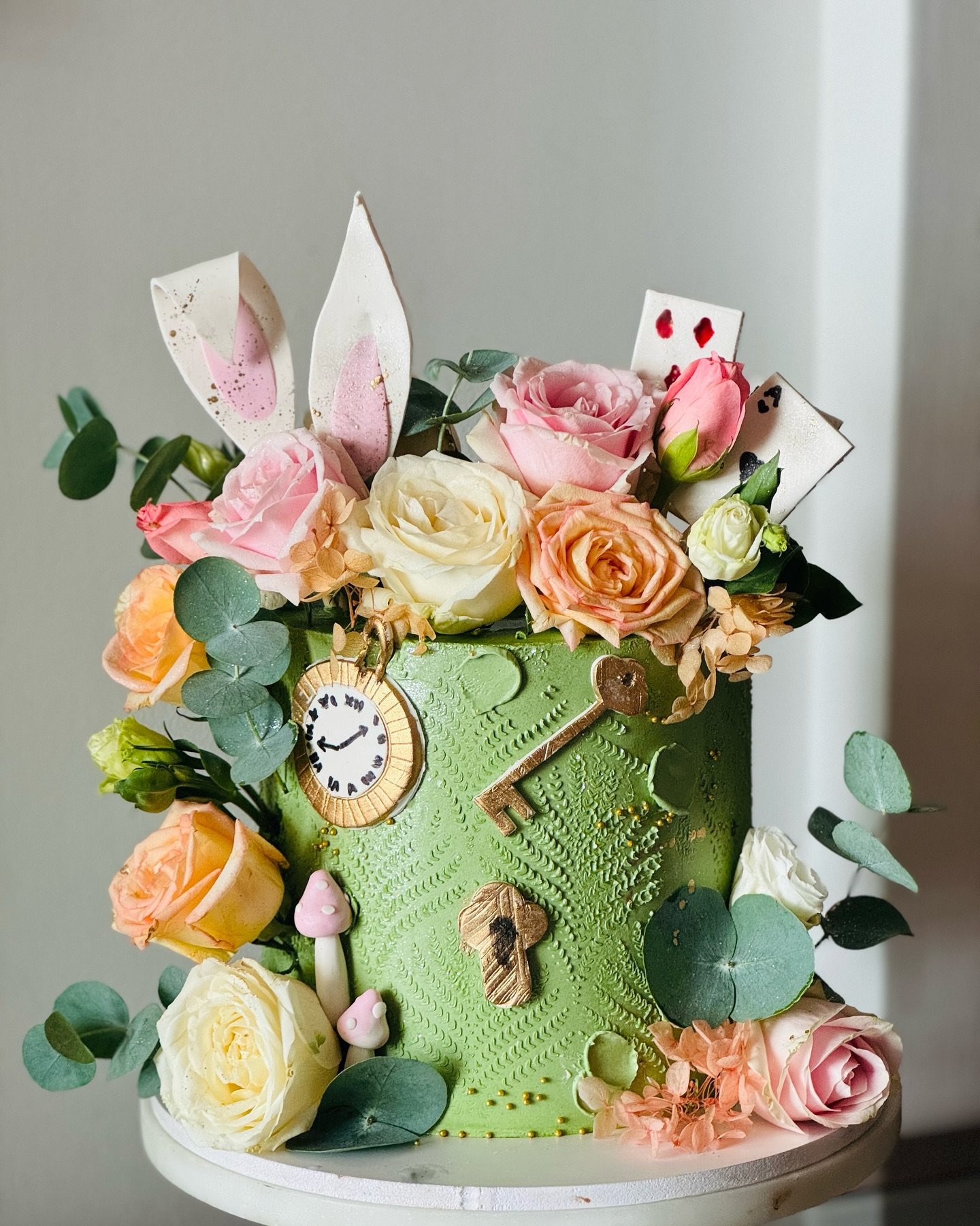 Soft pink floral celebration cake styled with ribbons and gift boxes
